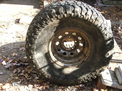 1996 Ford Bronco - Close-up of a off-road tire and rim resting on blocks.