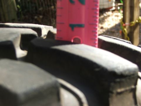 1996 Ford Bronco - Tire tread depth measured with a pink ruler.