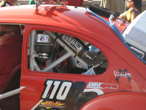 1996 Ford Bronco - A red racing car's interior is visible, a roll cage, Bilstein shock absorber, and the number 110 on its side.