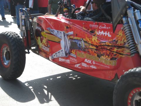 1996 Ford Bronco - This off-road buggy features a flame graphic and 'Baja Rescue Project' branding, suggesting participation in desert racing events.