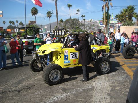 1996 Ford Bronco - A yellow off-road buggy with racing decals and number 1801 is parked on a street with spectators.