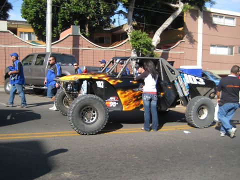 1996 Ford Bronco - A custom off-road buggy with flame graphics is parked on a street, with people around it.