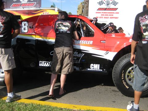 1996 Ford Bronco - A race truck is being prepared by crew members at an event.