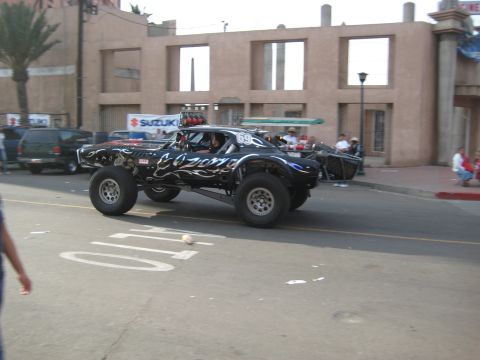 1996 Ford Bronco - This heavily modified off-road truck features flame decals and racing numbers, suggesting it is prepared for competition.