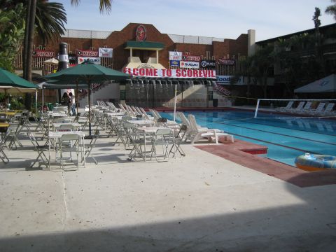 1996 Ford Bronco - An outdoor pool area is set up with tables and chairs, a waterfall and banners that read "Welcome to Scorevil".