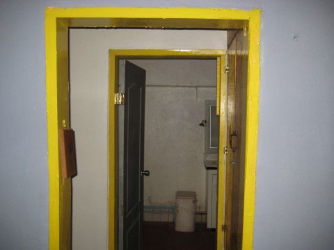 1996 Ford Bronco - View through a brightly painted yellow doorway into an interior space with an open door.