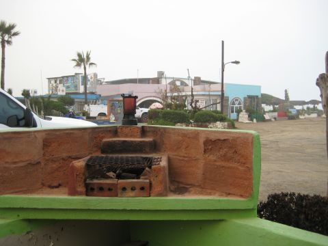 1996 Ford Bronco - A white SUV is visible in the foreground, parked near a barbecue pit with buildings in the background.