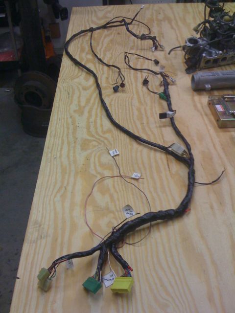 1987 Suzuki Samurai - A complex wiring harness is laid out on a workbench, showing various connectors and labeled wires.