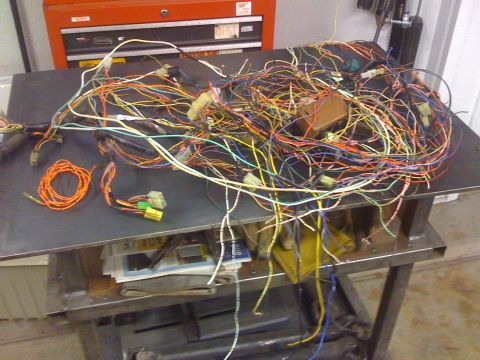 1987 Suzuki Samurai - A complex automotive wiring harness lies in a tangled heap on a workbench.