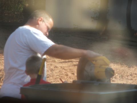 2005 Ford Mustang - A man and a child are seen with a chop saw in an outdoor setting.