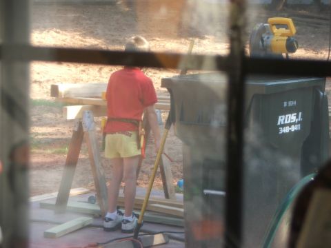 2005 Ford Mustang - A child stands in a yard with construction materials and a trash can.