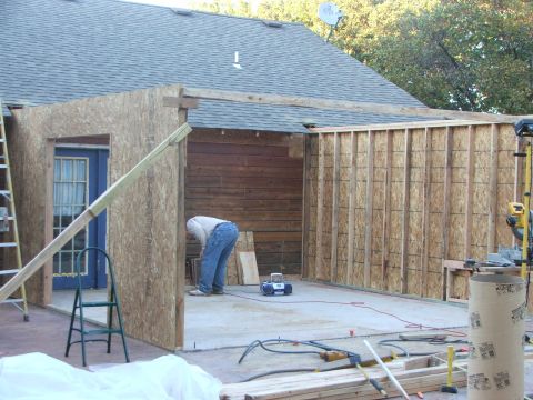 2005 Ford Mustang - A person works on framing a new room addition attached to a house.