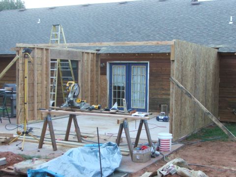 2005 Ford Mustang - A construction site shows a miter saw, ladders, and building materials, indicating ongoing home renovation.