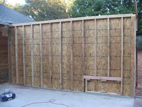 2005 Ford Mustang - An unfinished wall structure stands on a concrete surface, with a boombox and a red cord nearby.