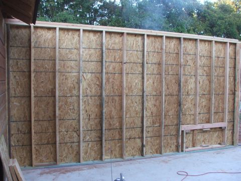 2005 Ford Mustang - An unfinished wall constructed with wooden studs and OSB panels is visible, with a Supermotors.net logo at the bottom right.