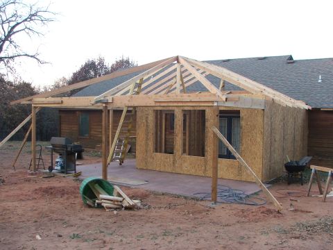 2005 Ford Mustang - A house addition is under construction, with roof trusses and exterior walls being framed.