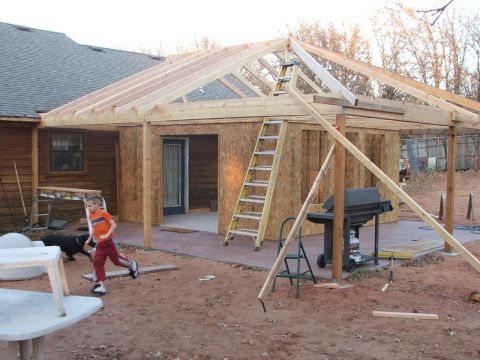 2005 Ford Mustang - A house addition is under construction, with a young boy and a dog present in the yard.