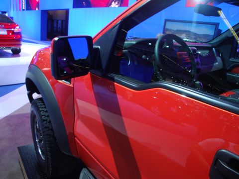 1993 Ford Taurus - A red truck is displayed indoors, with another red vehicle visible behind it.