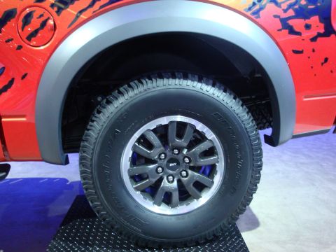 1993 Ford Taurus - Close-up of a red truck's wheel an SVT logo and tire tread.
