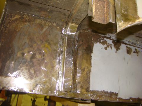 1948 Jeep Wrangler - Detail of a vehicle's frame showing rust and repair work, likely undergoing restoration.