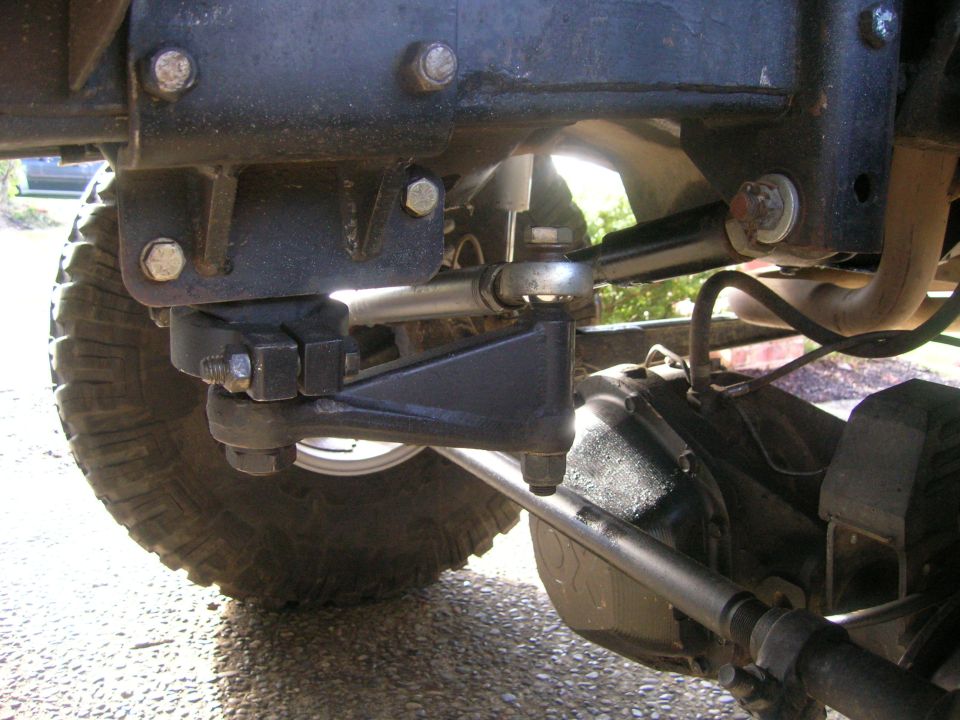 Undercarriage of a vehicle, showing suspension and steering components, with a tire visible
