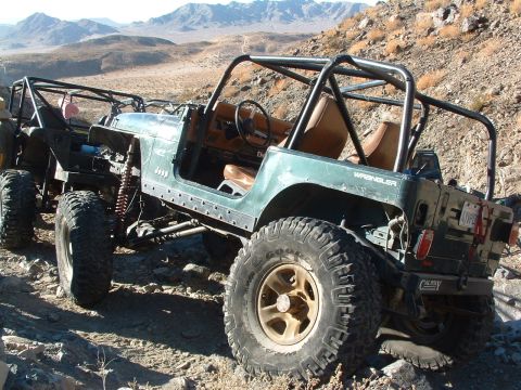 1994 Jeep YJ - Modified Jeeps tackle a rocky desert trail, their off-road capabilities.