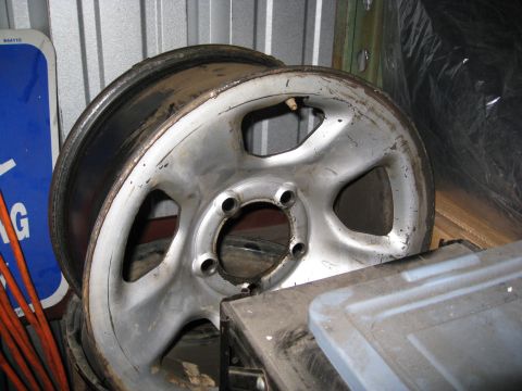 1994 Jeep YJ - A single, used aluminum wheel rim is shown in this close-up photo, resting on a storage container.