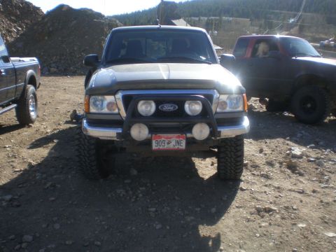 1996 Ford Bronco - A gray Ford Ranger pickup truck is parked outdoors, with another truck visible to the right.