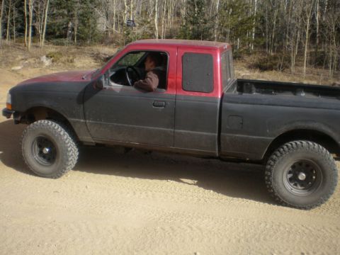 1996 Ford Bronco - Side view of a modified Ford Ranger pickup truck on a dirt road.