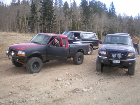 1996 Ford Bronco - A black Ford Bronco is parked on a dirt road with two Ford Rangers.