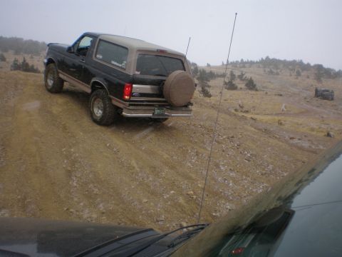 1996 Ford Bronco - Ford Bronco navigates a challenging off-road terrain on a cloudy day.