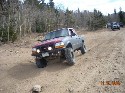 2004 Ford Ranger - A 2004 Ford Ranger navigates a rough, dirt trail with other vehicles in the background.