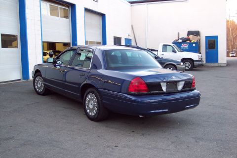 2001 Ford Crown Victoria - Rear view of a blue 2001 Ford Crown Victoria parked outside a commercial building.
