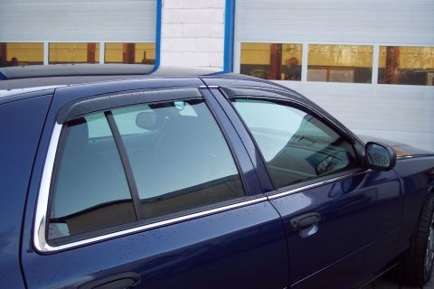 2001 Ford Crown Victoria - The side profile of a dark blue 2001 Ford Crown Victoria, chrome accents and in-channel window visors.