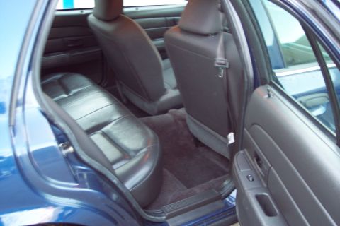 2001 Ford Crown Victoria - Interior view of the rear seats and door panel of a blue sedan.