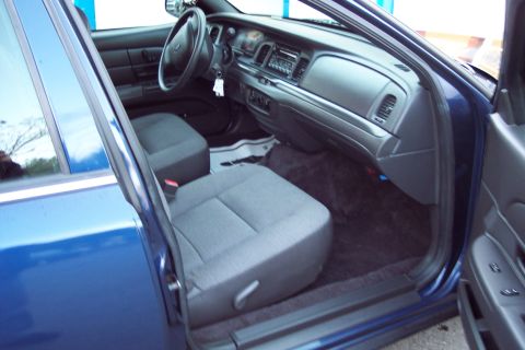 2001 Ford Crown Victoria - The interior of a blue sedan is shown, cloth seats and a standard dashboard layout.