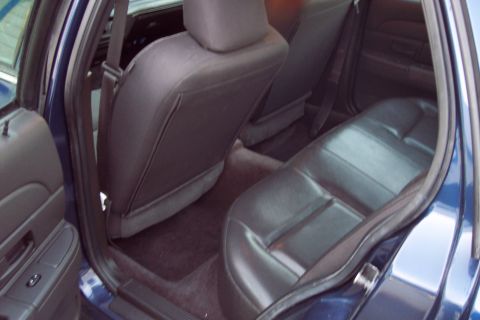 2001 Ford Crown Victoria - The interior of a blue car shows the rear seats and a portion of the door panel.