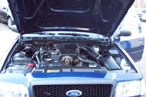 2001 Ford Crown Victoria - The engine bay of a blue 2001 Ford Crown Victoria is visible with the hood open.