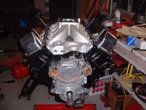 1983 Ford Bronco - V8 engine assembly with aftermarket intake and valve covers, mounted on a red engine stand.