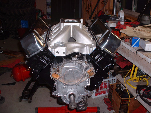 V8 engine on a stand with aluminum intake manifold and chrome valve covers