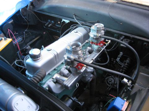 1953 Ford Mainline - Close-up view of a vehicle's engine compartment, dual carburetors and a silver valve cover.