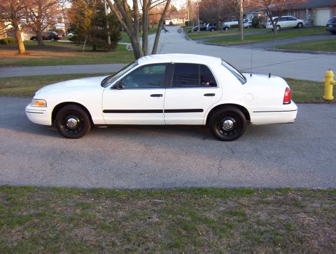 2003 Ford Crown Victoria - Side profile of a white 2003 Ford Crown Victoria sedan parked on a residential street.
