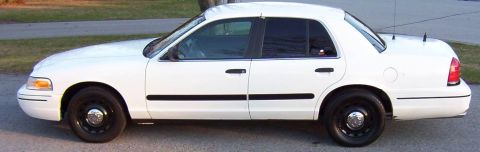 2003 Ford Crown Victoria - Side view of a white 2003 Ford Crown Victoria sedan with black trim and steel wheels.