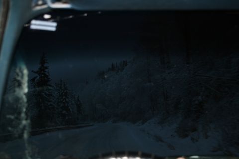 1990 Chevrolet Suburban - Driving through a snow-covered forest on a dark, winter evening.