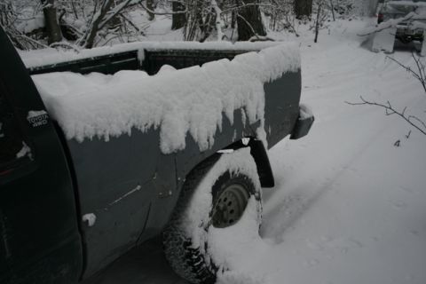 1990 Chevrolet Suburban - A Toyota 4WD pickup truck is parked in a snowy wooded area, with another vehicle visible in the distance.