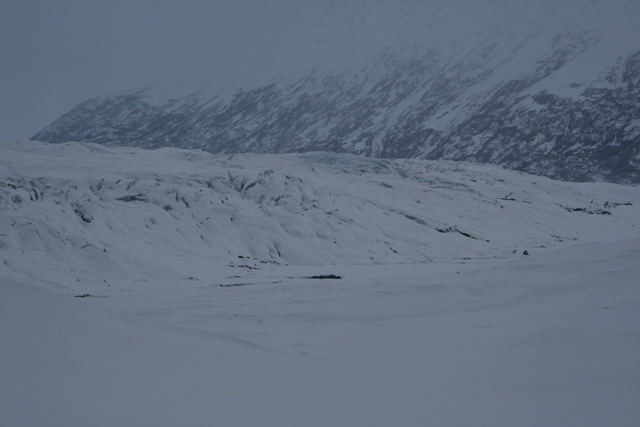 Snowy mountains and a vast glacier under a cloudy sky