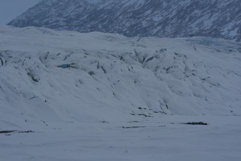 1990 Chevrolet Suburban - A vast, snow-covered glacier stretches towards mountains under an overcast sky.