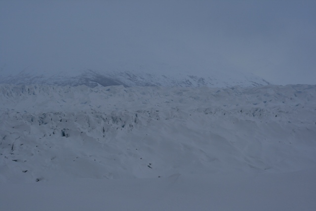 Snowy landscape with mountains in the background and a glacier in the midground