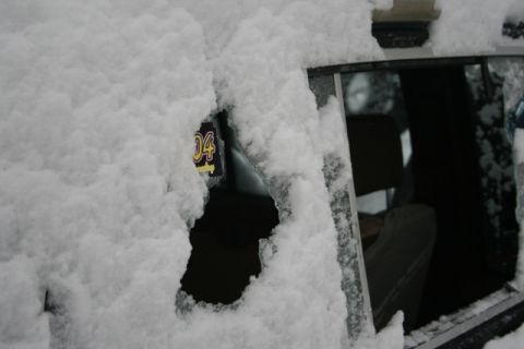 1990 Chevrolet Suburban - A license plate with the year '04' is partially visible through a snow-covered car window.