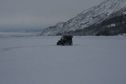 1990 Chevrolet Suburban - Jeep Wrangler traversing a vast snowy expanse under a cloudy sky.